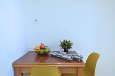 a table with chairs and a bowl of fruit on it at A heart apartment at Skouze Hill, Dirrachiou in Athens