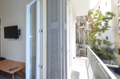 a room with a balcony with a table and a window at A heart apartment at Skouze Hill, Dirrachiou in Athens