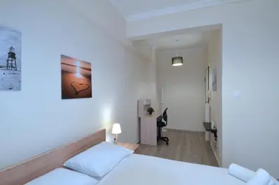 a white room with a bed and a hallway at A heart apartment at Skouze Hill, Dirrachiou in Athens