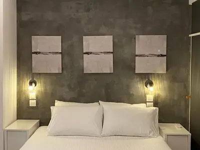 a bedroom with a bed with three paintings on the wall at George House in Athens