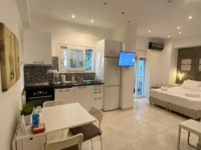 a kitchen and living room with a couch and a table at George House in Athens