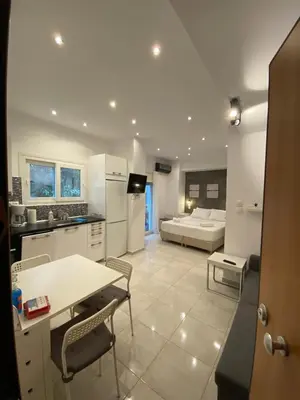 a kitchen and a living room with a table and chairs at George House in Athens