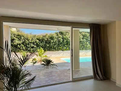 an open sliding glass door with a view of a pool at Pool Villa Lagonisi 5min from Beach in Koropíon