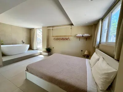 a bedroom with a bed and a bath tub and a sink at Pool Villa Lagonisi 5min from Beach in Koropíon
