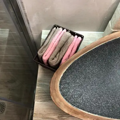 a basket of towels in a bathroom next to a mirror at Μία γκαρσονιέρα με γούστο για επισκέπτες με άποψη in Athens