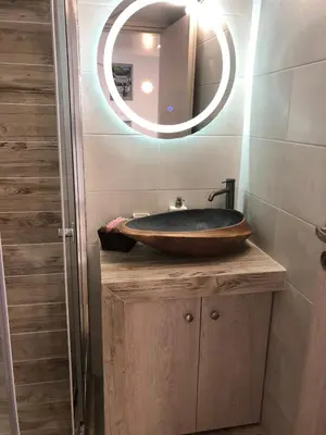 a bathroom with a wooden sink and a mirror at Μία γκαρσονιέρα με γούστο για επισκέπτες με άποψη in Athens
