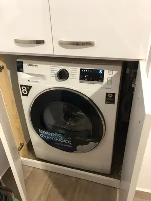 a white washing machine in a kitchen under a counter at Μία γκαρσονιέρα με γούστο για επισκέπτες με άποψη in Athens