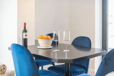 a dining room table with blue chairs and a bottle of wine at The 