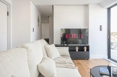 a living room with a white couch and a tv at The 