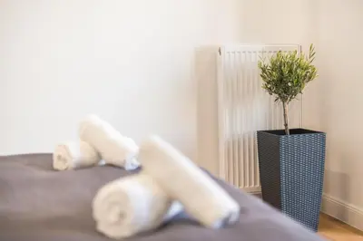 a room with a bed with a vase with a plant at The 