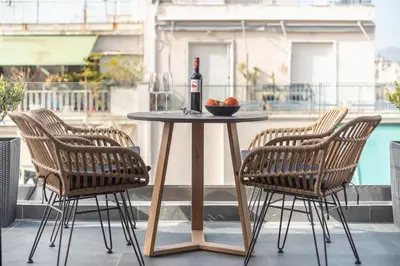 a table with a bottle of wine and two chairs at The 