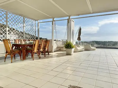 a patio with a table and chairs on a balcony at Villasonboard 3 Bed Penthouse Veranda Beach view jacuzzi Vouliagmeni Riviera in Athens
