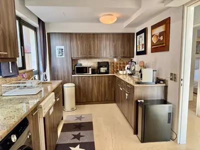 a kitchen with wooden cabinets and a counter top at Villasonboard 3 Bed Penthouse Veranda Beach view jacuzzi Vouliagmeni Riviera in Athens