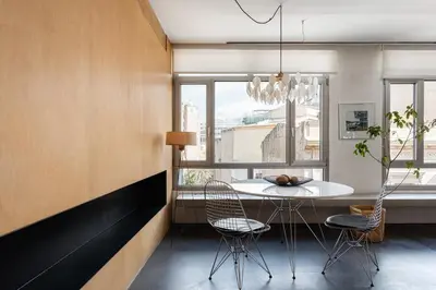 a dining room with a table and chairs and a window at Syntagma Designers Living in Athens