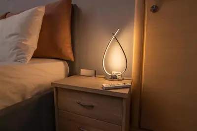 a lamp on a night stand next to a bed at Luxury suite 10’ from the center in Athens
