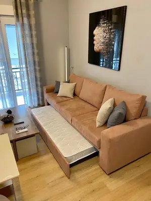 a brown couch in a living room with a table at Luxury suite 10’ from the center in Athens
