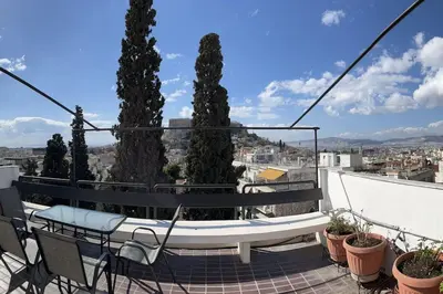 a balcony with a bench and some trees at So Athens - Luminous duplex apt in Plaka, Acropolis views in Athens