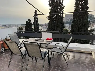 a patio with a table and chairs on a balcony at So Athens - Luminous duplex apt in Plaka, Acropolis views in Athens