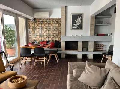 a living room with a couch and a table and a fireplace at So Athens - Luminous duplex apt in Plaka, Acropolis views in Athens