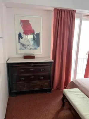 a bedroom with a dresser with a picture on the wall at So Athens - Luminous duplex apt in Plaka, Acropolis views in Athens