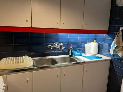 a kitchen with a sink and a blue tiled wall at So Athens - Luminous duplex apt in Plaka, Acropolis views in Athens