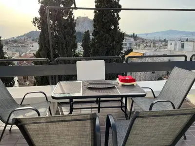 a table and chairs on a balcony with a view at So Athens - Luminous duplex apt in Plaka, Acropolis views in Athens