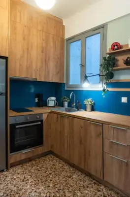 a kitchen with wooden cabinets and a black dishwasher at Museum Apartment - Fix B, Athens in Athens