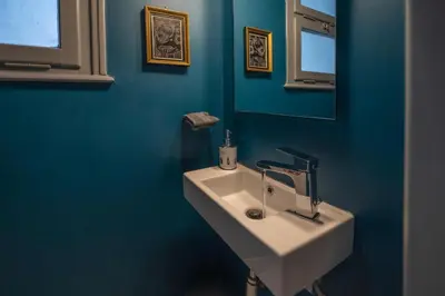 a bathroom with a white sink and a blue wall at Museum Apartment - Fix B, Athens in Athens