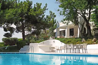 a swimming pool with chairs and a house at Villa Oasis with Large Pool Athenian Riviera Lagonissi in Lagonissi