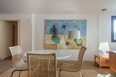 a dining room with a table and chairs and a painting at Villa Oasis with Large Pool Athenian Riviera Lagonissi in Lagonissi