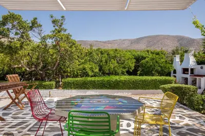 a patio with colorful chairs and a table with at Villa Oasis with Large Pool Athenian Riviera Lagonissi in Lagonissi