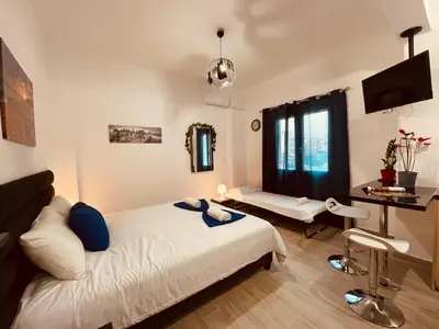 a bedroom with a bed and a desk in it at Diamond Apartment in Athens