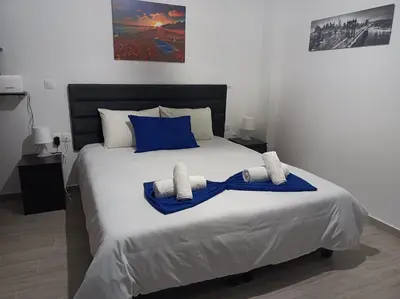 a bedroom with a large white bed with blue pillows at Diamond Apartment in Athens