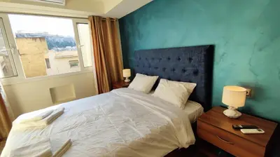 a bedroom with a large bed with a blue wall at Acropolis of Athens from Ermou str in Athens