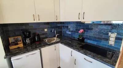a kitchen with a sink and a blue tile wall at Acropolis of Athens from Ermou str in Athens