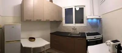 a small kitchen with brown cabinets and a sink at Cosy apartment in Metaxourgeio in Athens