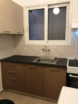 a kitchen with a sink and two windows at Cosy apartment in Metaxourgeio in Athens