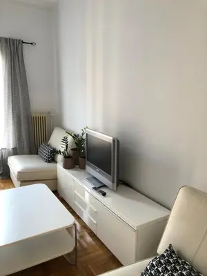 a living room with a flat screen tv on a table at Cosy apartment in Metaxourgeio in Athens