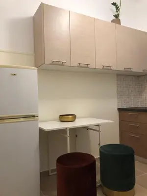 a kitchen with a table and two stools at Cosy apartment in Metaxourgeio in Athens