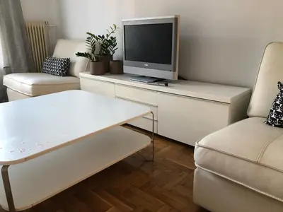 a living room with a tv on a white cabinet at Cosy apartment in Metaxourgeio in Athens