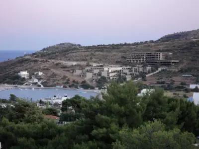 a town on a hill next to a body of water at Eri Studios in Agia Marina Aegina