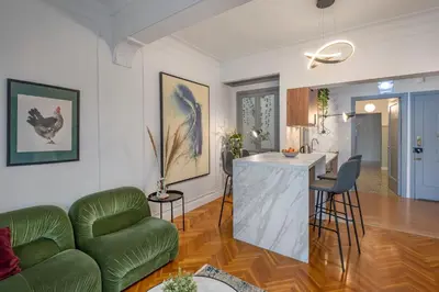 a living room with a green couch and a kitchen at Museum Apartment - Fix A, Athens in Athens