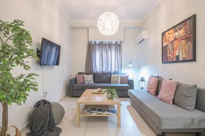 a living room with a couch and a table at Erythros Boutique Suite By Cloudkeys in Athens