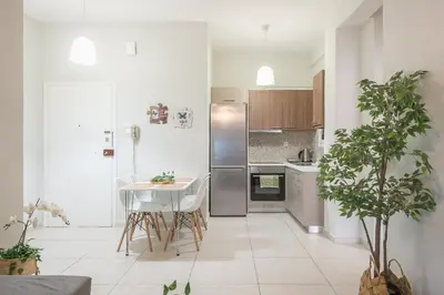 a kitchen with stainless steel appliances and a table and chairs at Erythros Boutique Suite By Cloudkeys in Athens