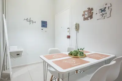 a white room with a table and white chairs at Erythros Boutique Suite By Cloudkeys in Athens