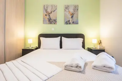 a bedroom with a bed with two towels on it at Erythros Boutique Suite By Cloudkeys in Athens