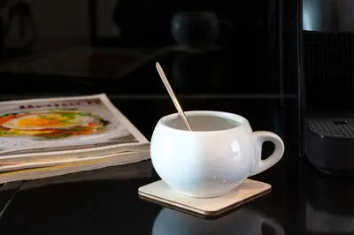 a cup of coffee with a spoon in it on a table at Dema Luxury Suites - Perikleous E8 in Athens