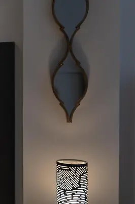 a mirror hanging on a wall next to a vase at Dema Luxury Suites - Perikleous E8 in Athens