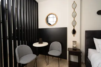 a bedroom with two chairs and a table and a bed at Dema Luxury Suites - Perikleous E8 in Athens