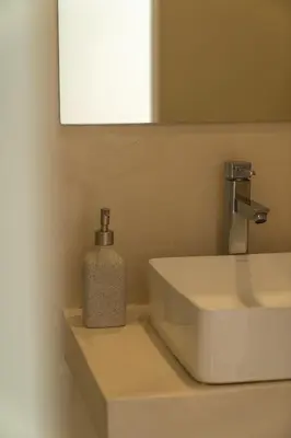 a soap dispenser sitting on a sink in a bathroom at Dema Luxury Suites - Perikleous E8 in Athens